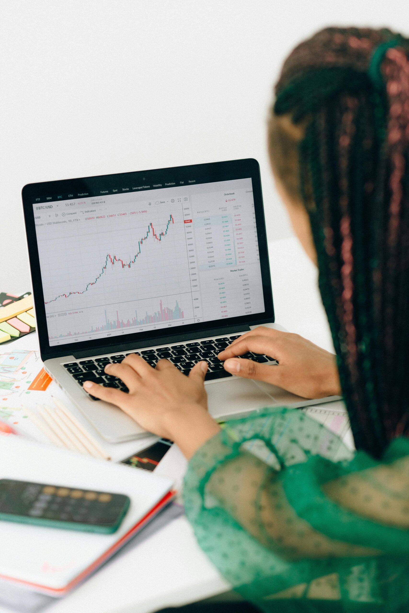 Person working on a computer with chart trending upwards